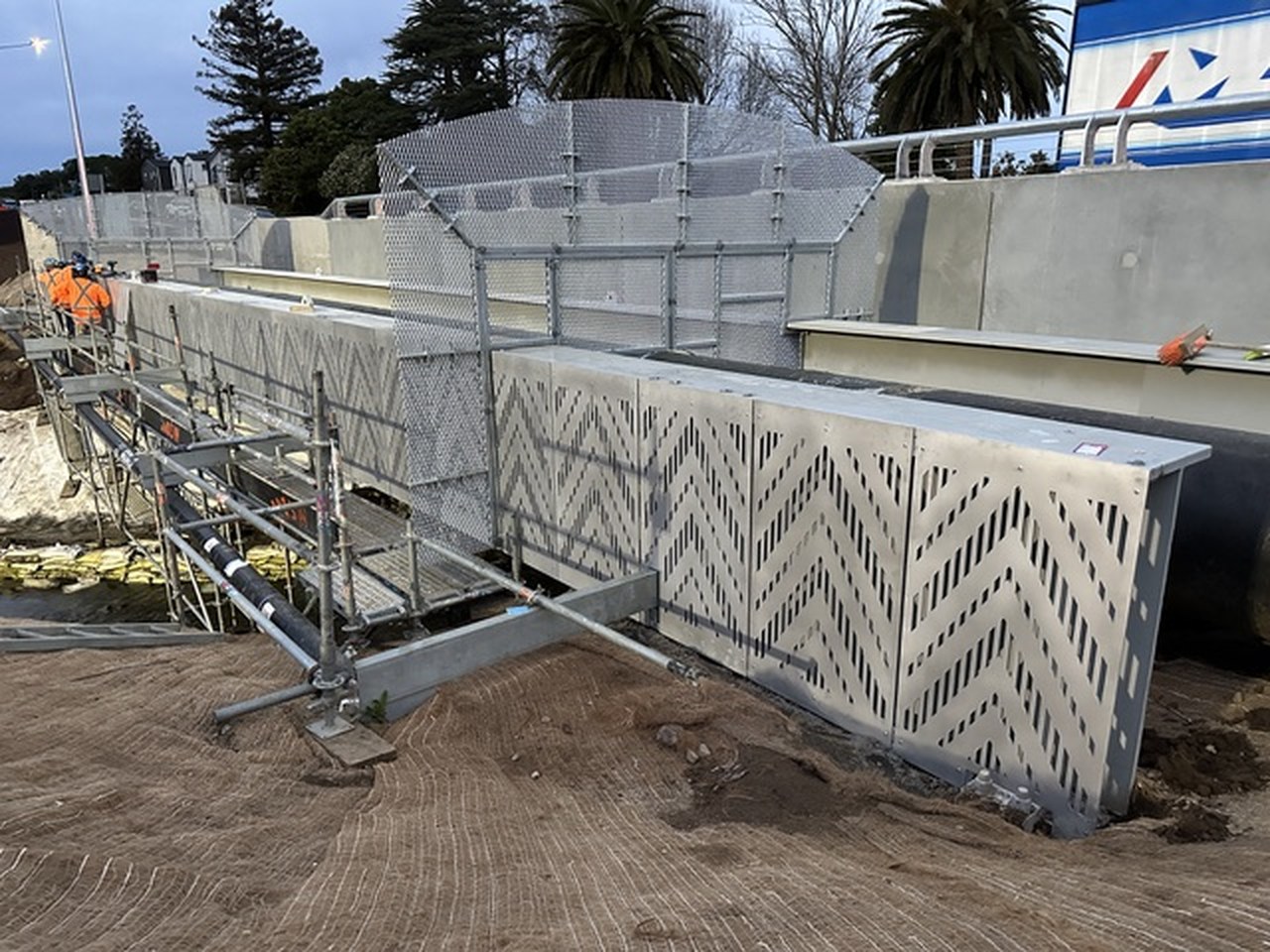 Perforated steel bridge screen with a chevron pattern, close view on site