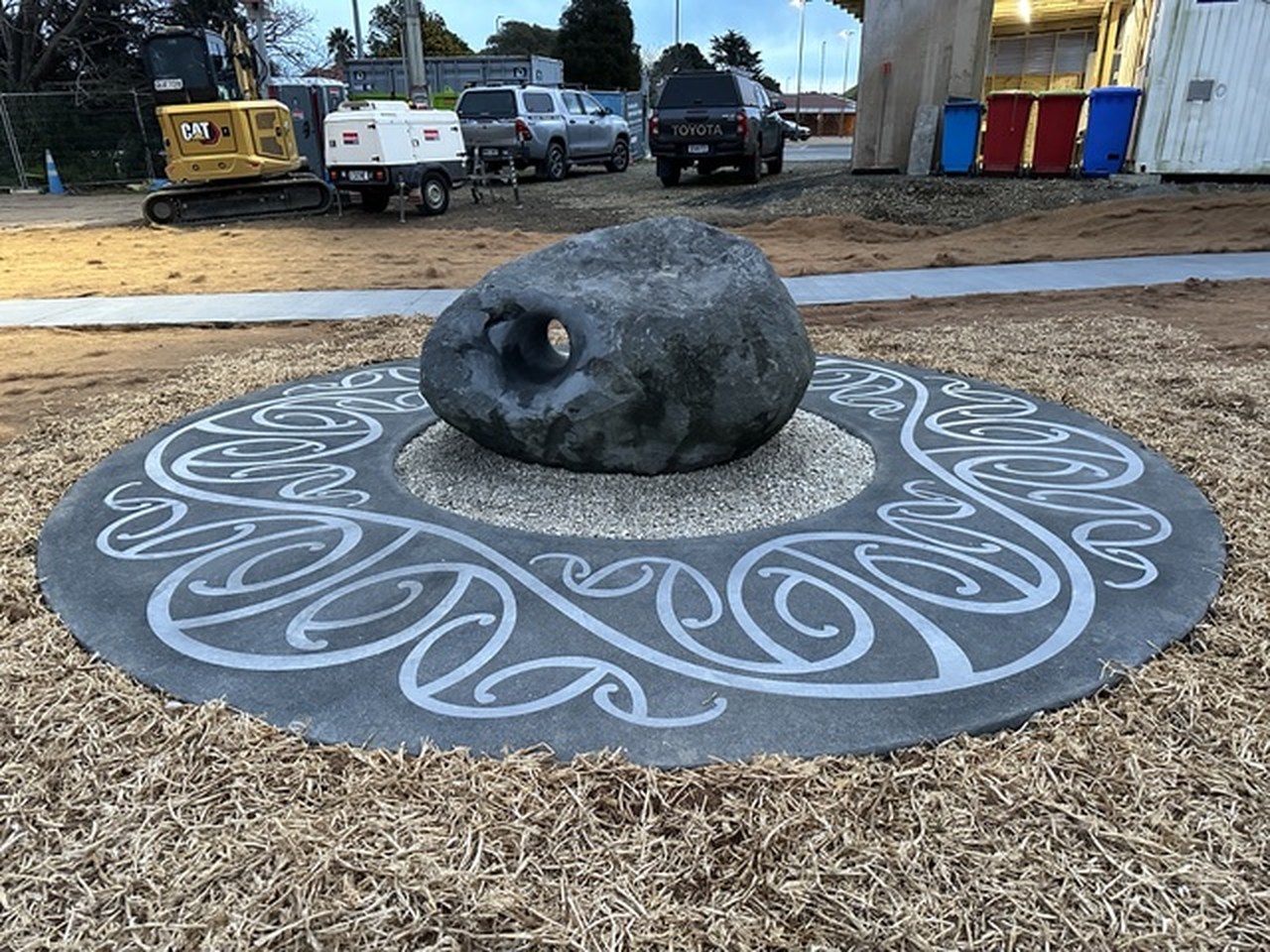 Carved stone set on an inlaid spiral concrete circle in a public reserve