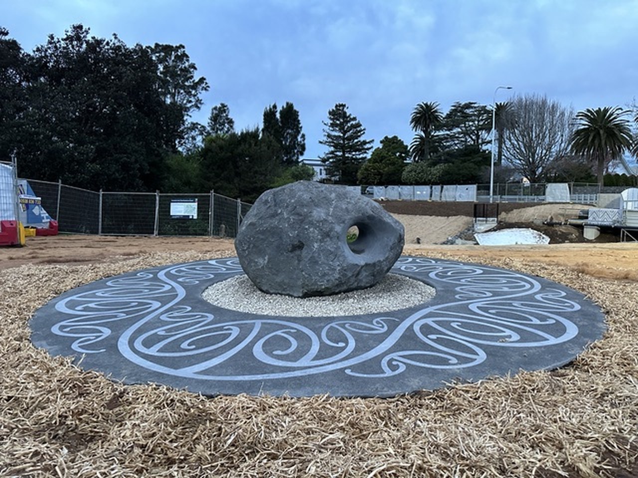 Carved stone set on an inlaid concrete circle in a public reserve