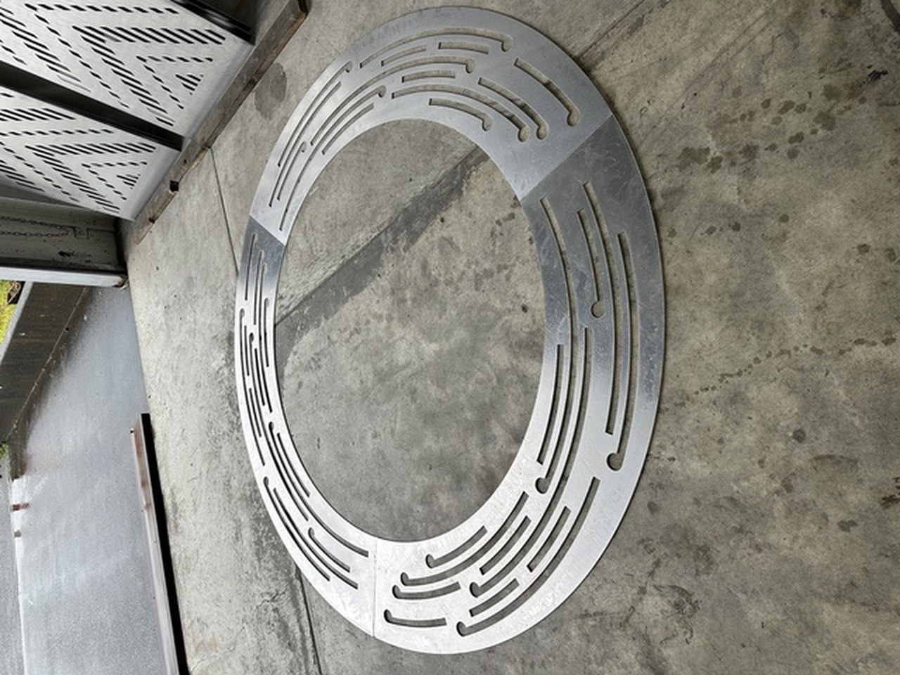Perforated steel ring detail set into a concrete panel